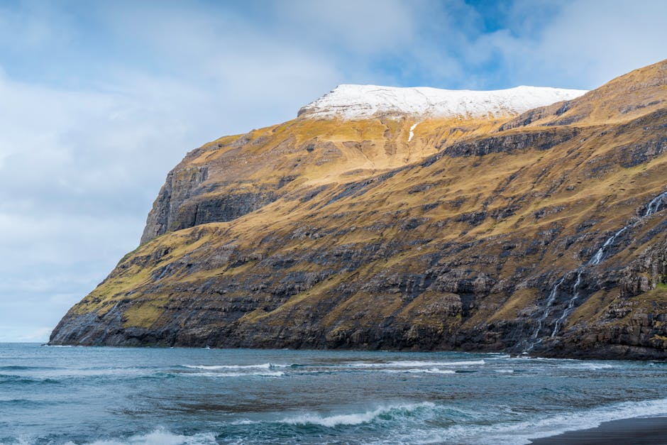 Explore the stunning scenic cliffs and ocean waves at the breathtaking Faroe Islands.