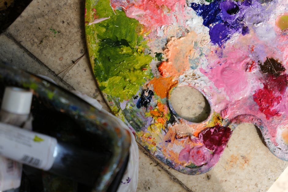 Colorful artist palette with vibrant acrylic paints and brush, creating art indoors.