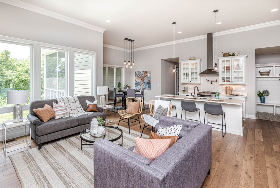 Spacious open-plan living room leading to a modern kitchen, featuring stylish furniture.