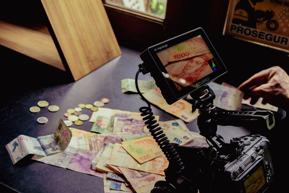 Film setup on table with mixed currency notes and coins, artistic shot.