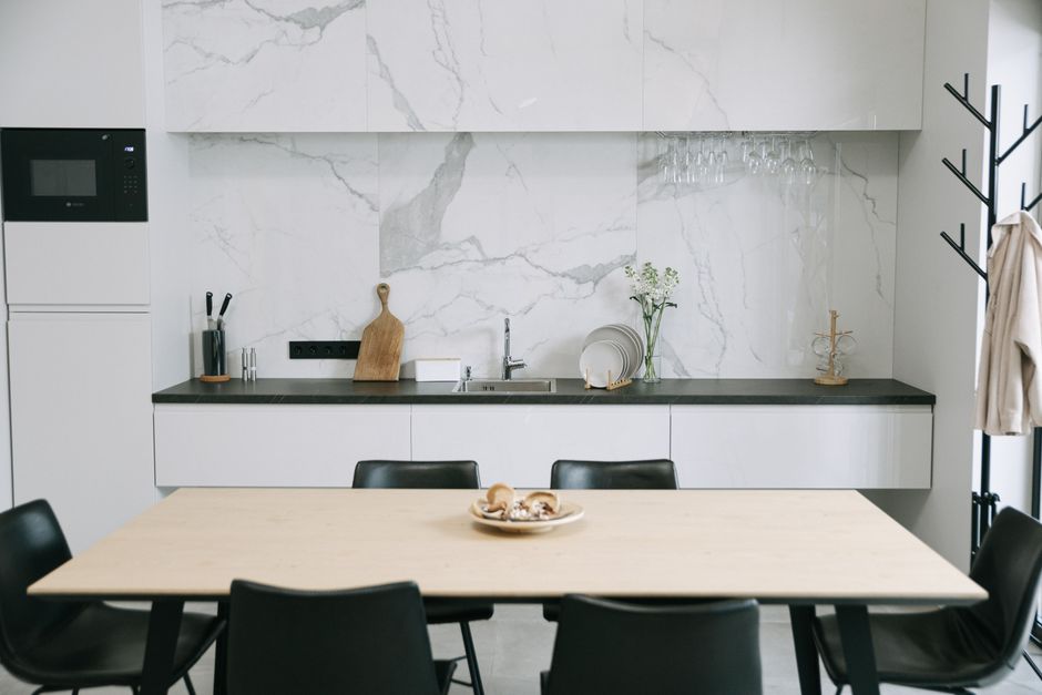 Sleek Japandi-style kitchen featuring marbled walls, dining setup, and minimalistic decor.