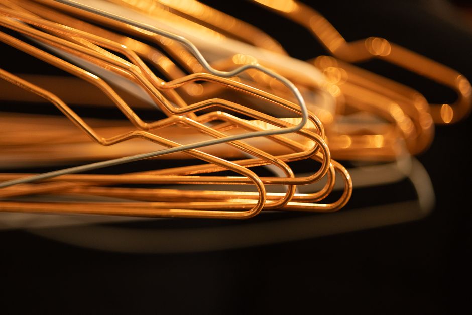 Close-up abstract composition of overlapping wire clothes hangers in warm lighting.