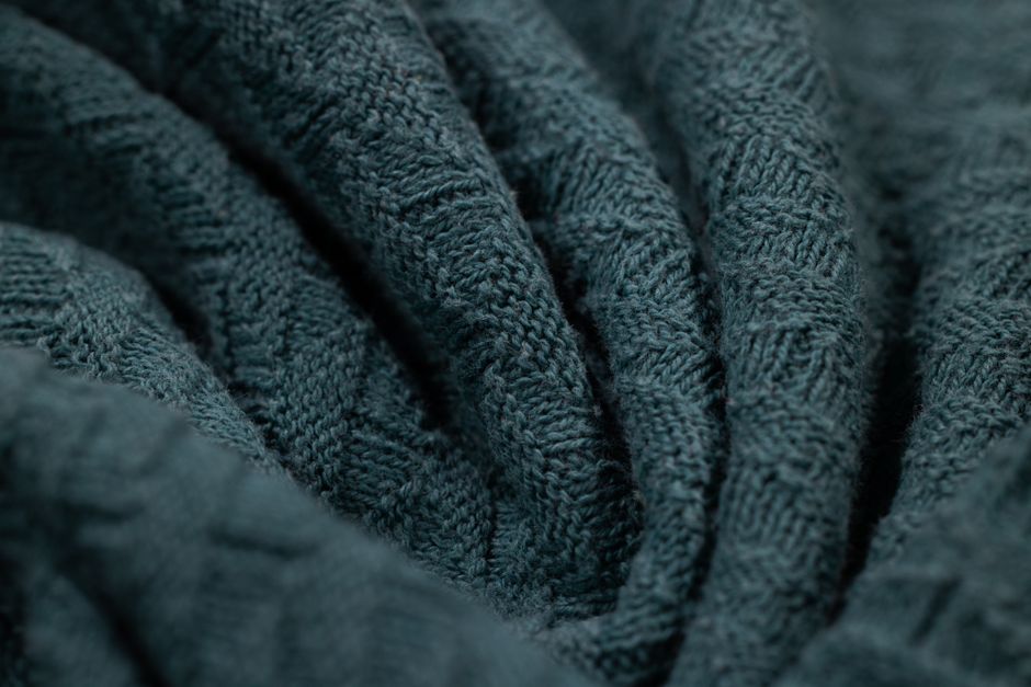 Detailed macro image of textured blue knitted fabric. Ideal for textile design and fashion.