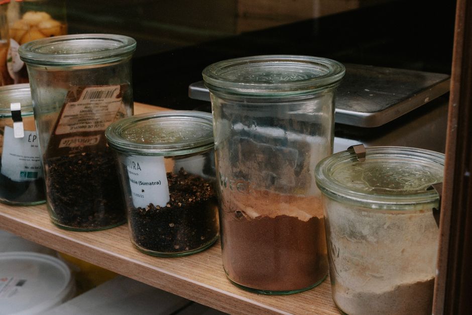 A variety of spices stored in glass jars lined on a shelf, perfect for kitchen organization.