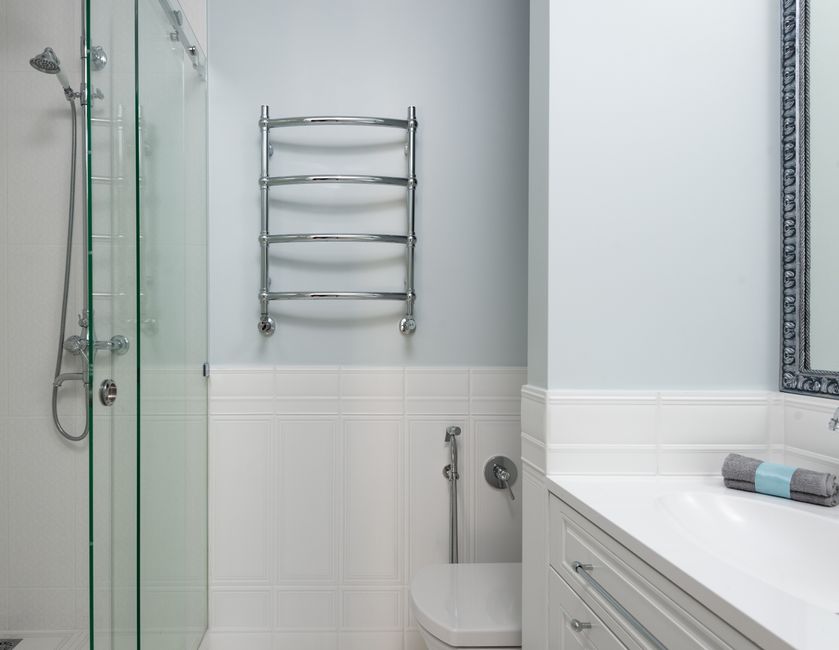 Interior of modern bathroom with sink on cabinet and toilet at wall near glass door of shower cabin at home