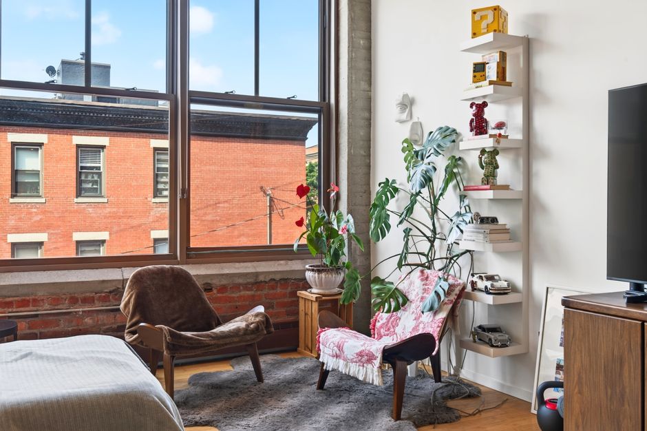Beautifully designed Boston apartment featuring industrial aesthetics with large windows and eclectic decor.