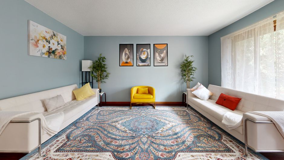 Spacious living room with minimalistic design, modern art, and vibrant colors.